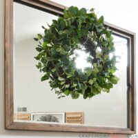 Easy DIY eucalyptus wreath hanging over a mirror above the mantel.