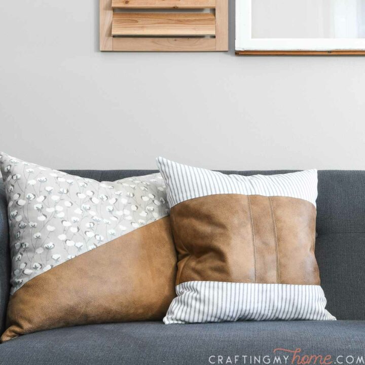 DIY farmhouse pillows with faux leather and canvas colorblocking on a couch.