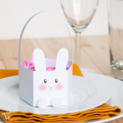 White paper bunny Easter basket with modern bunny face and pom pom feet.