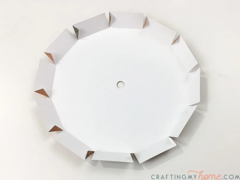 The center piece of the wall clock being folded. 