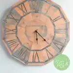 DIY pallet wood clock made out of paper with text overlay.