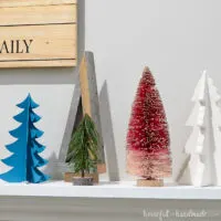 A variety of Christmas trees on the holiday mantel for decor.