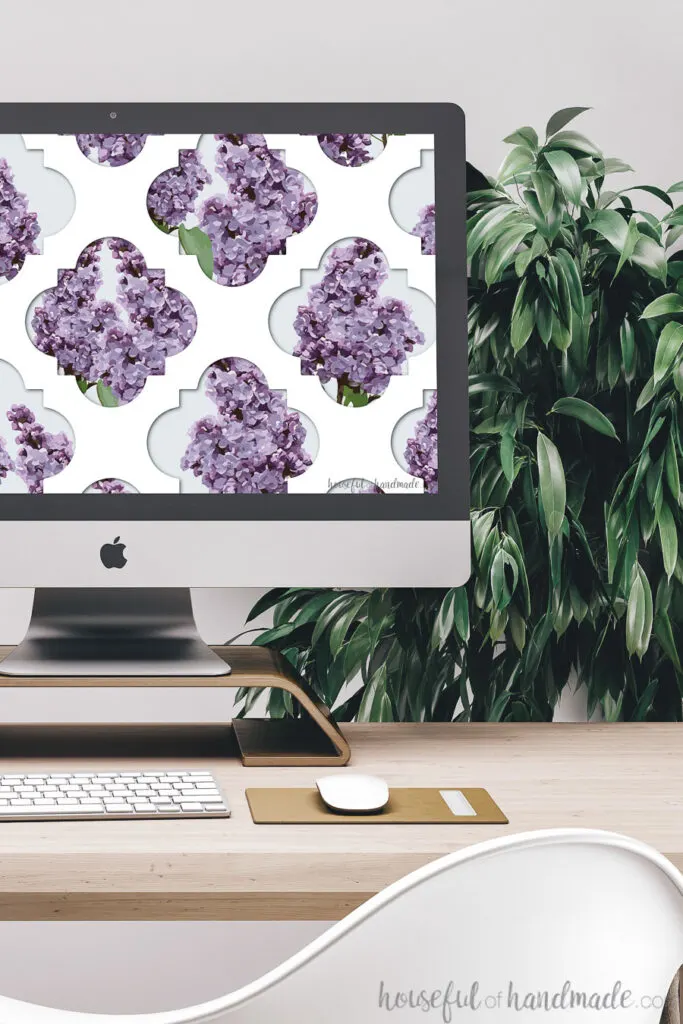 White lattice pattern with lilacs peeking through as a digital wallpaper on a computer screen.