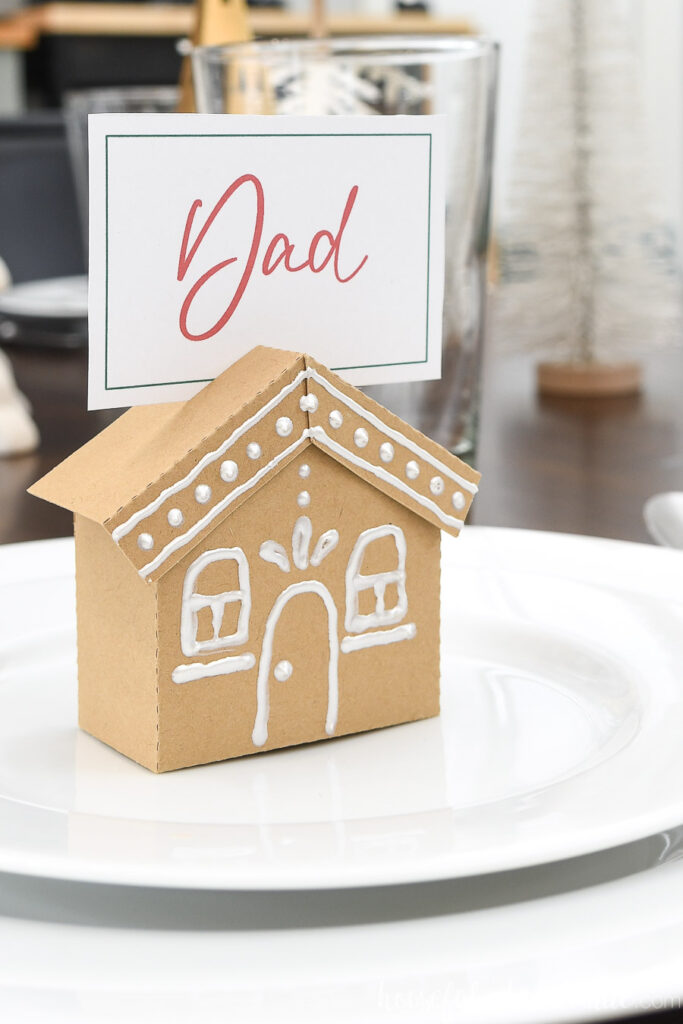 Close up of the gingerbread house place card holder with a place card for "Dad" in the top.