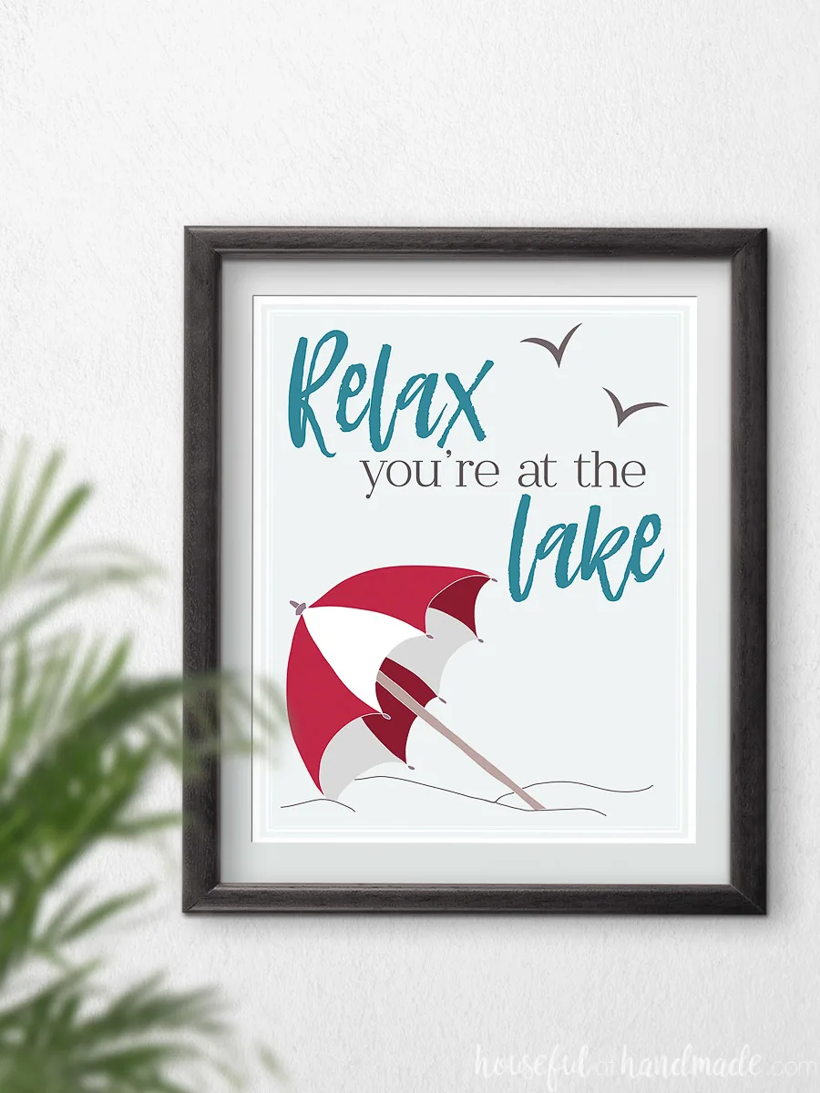 Red beach umbrella art with text "relax you're at the lake" in a frame. 