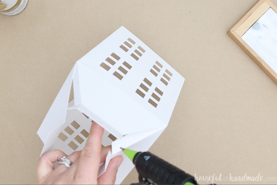 Glueing the top flaps to create the tapered top of the paper lantern.