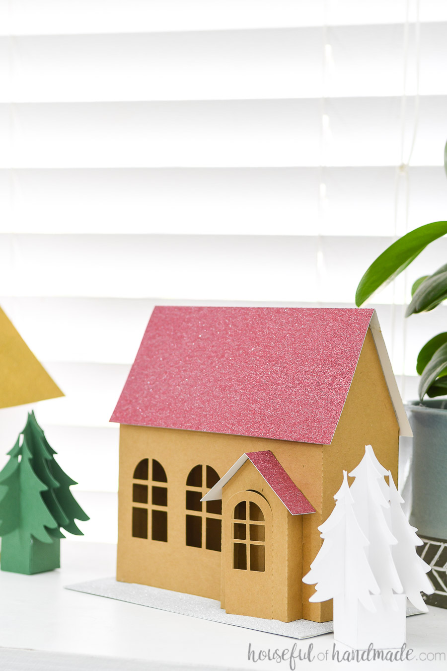 Close up of the brown kraft paper Christmas house with red glitter roof and 3D entryway.
