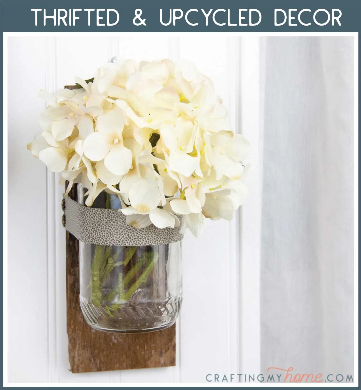 Wall vase made from upcycled items holding flowers with a navy box around it and white text: Thrifted & Upcycled Decor.