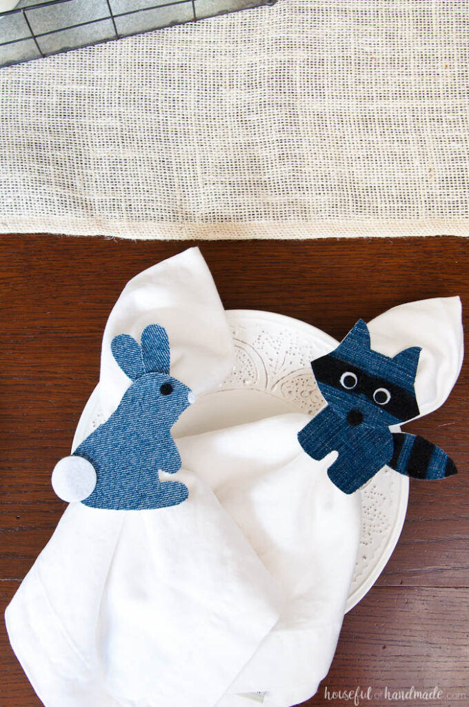 Two woodland critter napkin rings made from denim on a salad plate. 