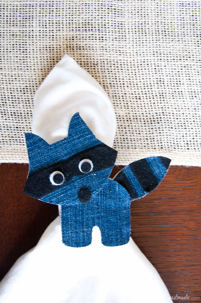 Close up of the raccoon napkin ring made with a dark denim stripe. 