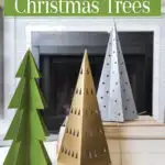 Christmas vignette with 3 paper Christmas trees painted green, gold and silver.
