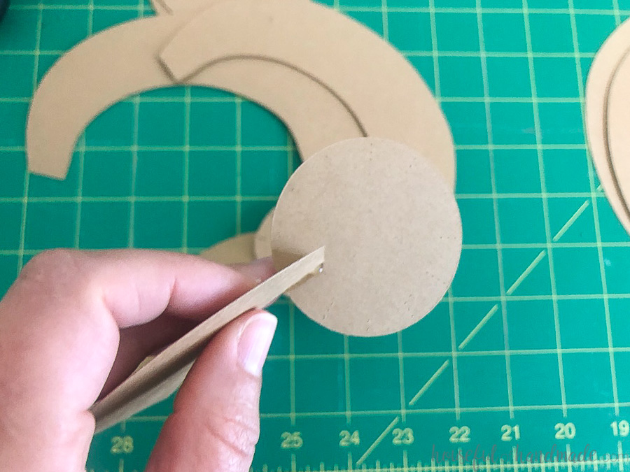 The first large piece glued to the bottom of the lower disk with a line of hot glue. 