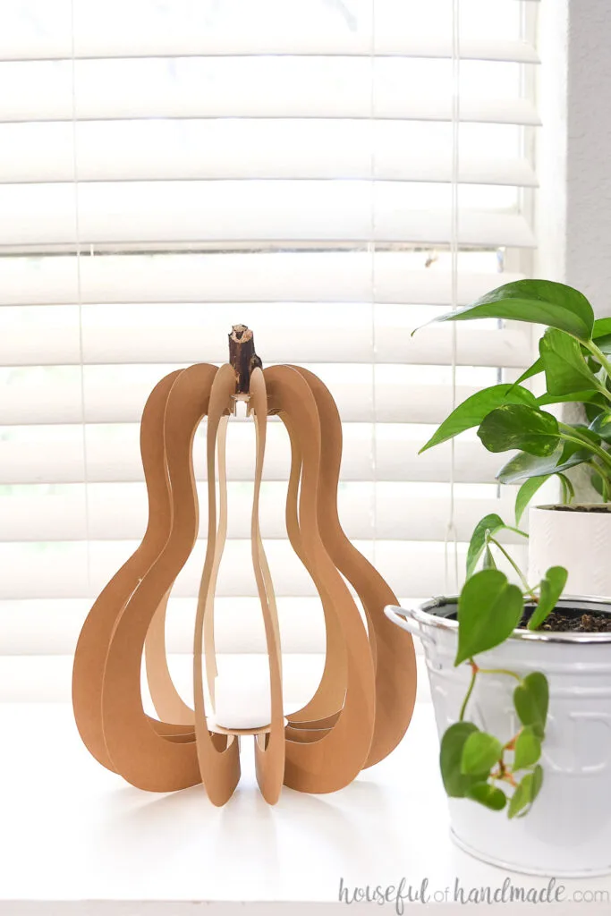 3D paper gourd craft sitting beside a pothos plant. 