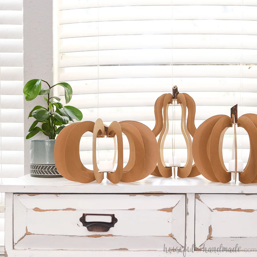 3D paper pumpkin lantern craft for adults on a console table.