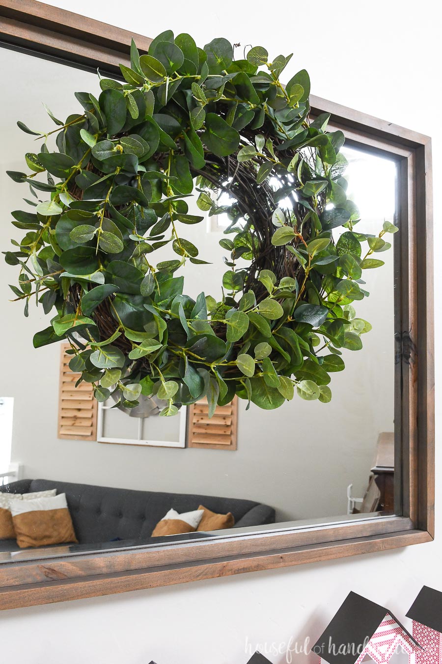 Beautiful faux eucalyptus wreath hanging over a mirror.