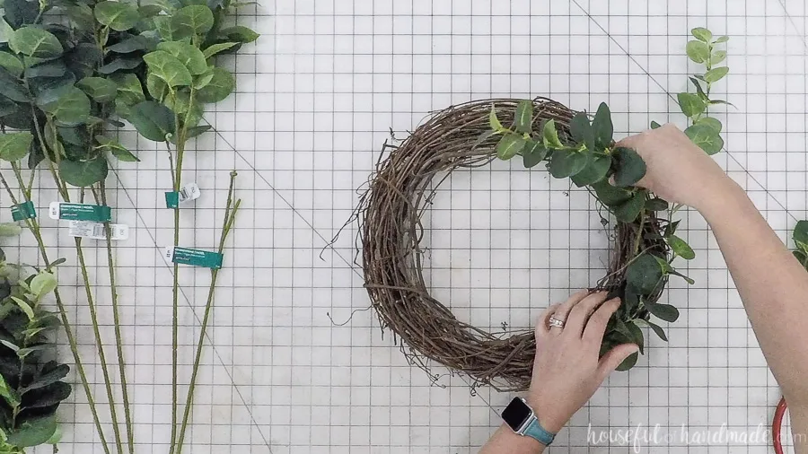 Inserting the eucalyptus springs into grapevine wreath form. 