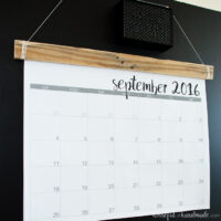 Giant wall calendar attached to a piece of reclaimed wood hanging on a chalkboard wall showing September calendar on the front.