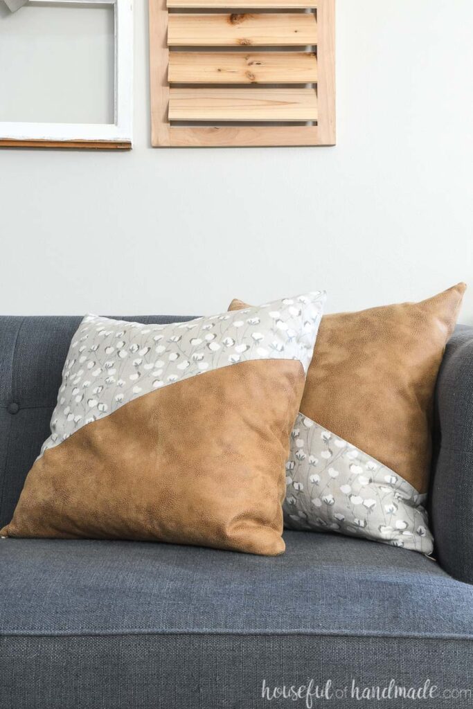 Handmade pillows with leather and canvas in a diagonal color blocking on the sofa. 