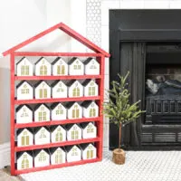Red house shaped shelf with 25 paper houses as a Christmas advent calendar.