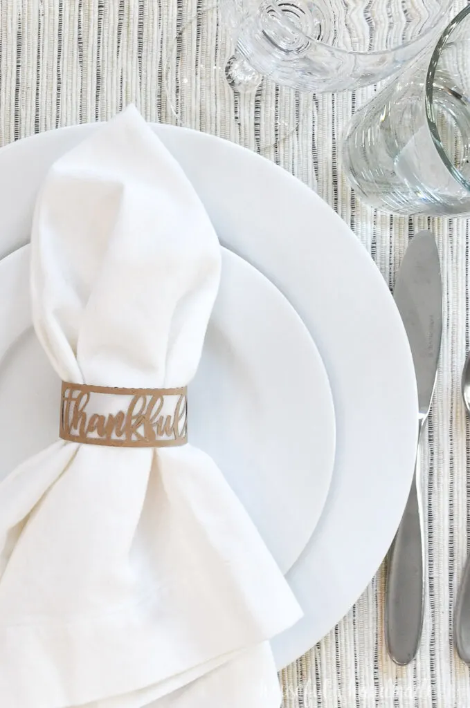 close up of paper thankful napkin ring on white place setting