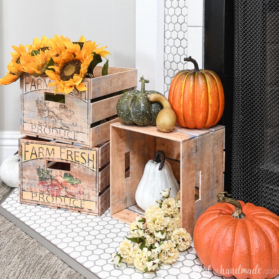 Three DIY crates in front of the fireplaces displaying pumpkins and sunflowers.