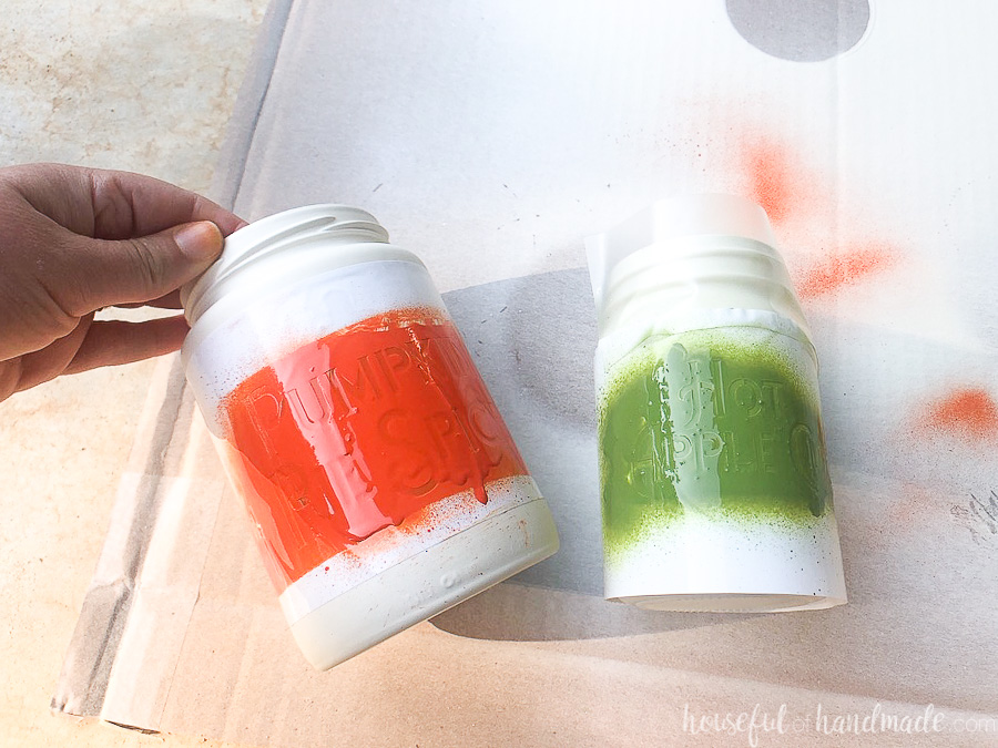 Vinyl stencil sprayed with orange and green color over the cream jars. 