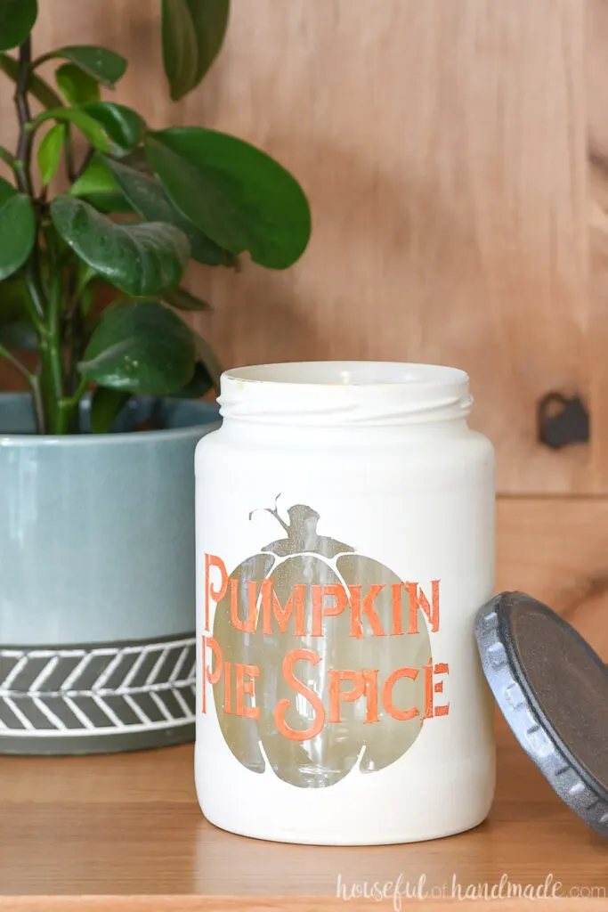 Close up of the Pumpkin pie spice kitchen canister with the lid off leaning up against the side. 