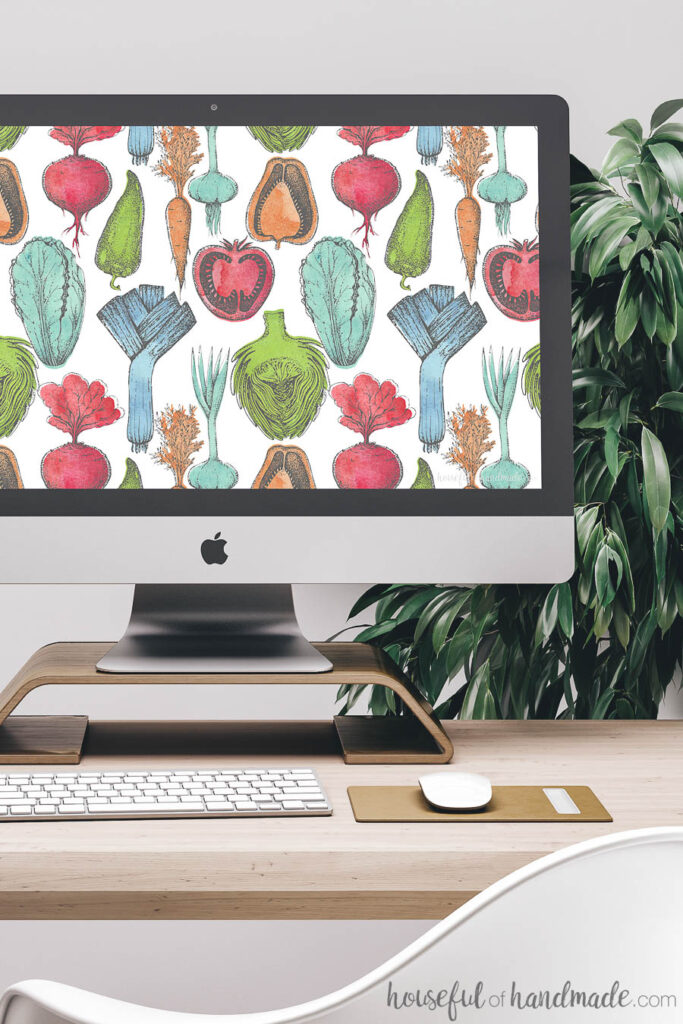 Desktop computer screen decorated with free digital wallpaper. The colorful watercolor produce design is reminiscent of summer farmers markets. 
