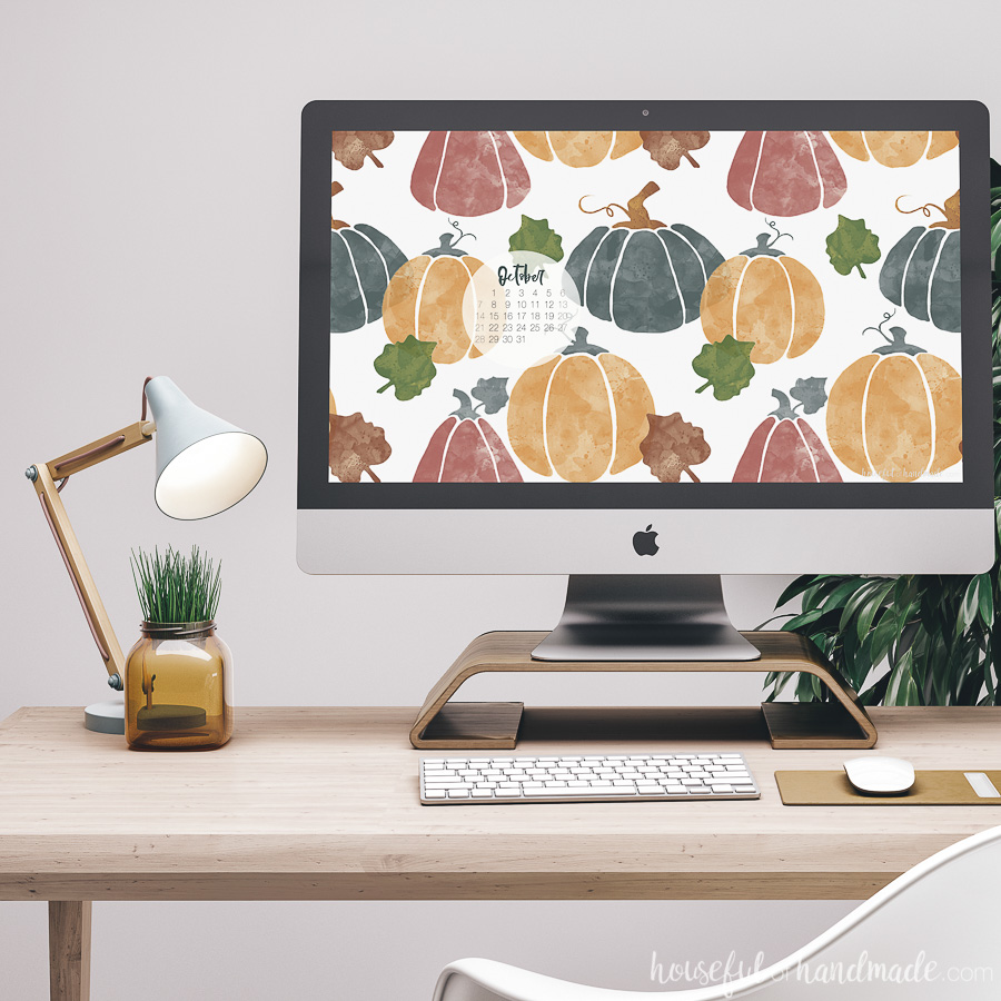 iMac computer on a desk with the free digital backgrounds for October on the screen. New October 2018 calendar on the background.