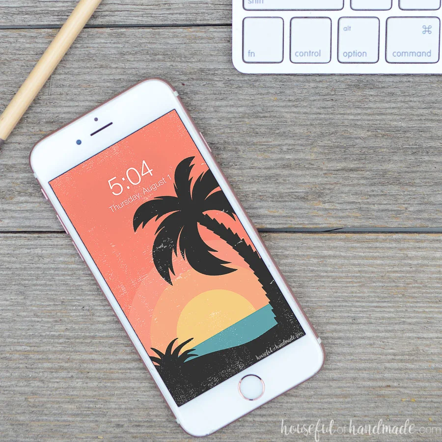 Rose gold iPhone with a retro tropical sunset digital wallpaper on the home screen. 