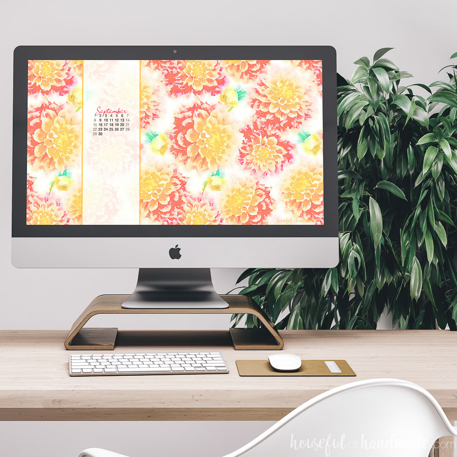 Desktop computer with watercolor dahlia wallpaper on the screen.