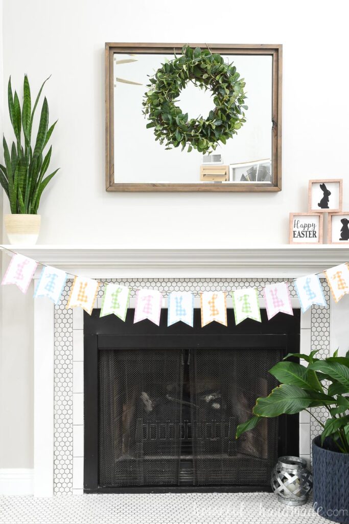 Fireplace decorated for Easter with simple bunny silhouette signs and a gingham bunny banner. 