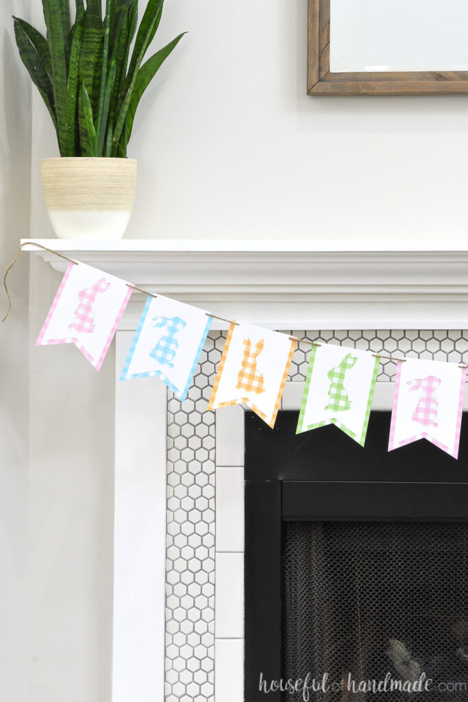 White tiled fireplace with gingham bunny banner hanging on the mantel.
