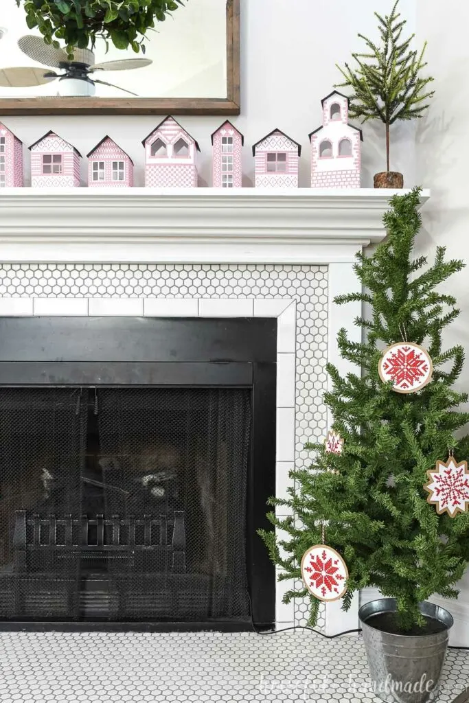 Christmas tree decorated with nordic cross tree ornaments next to fireplace