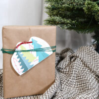 Printable Christmas gift card holder tied to a present under the tree.