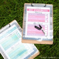 Printable Daily Chore Charts on clip boards on the grass