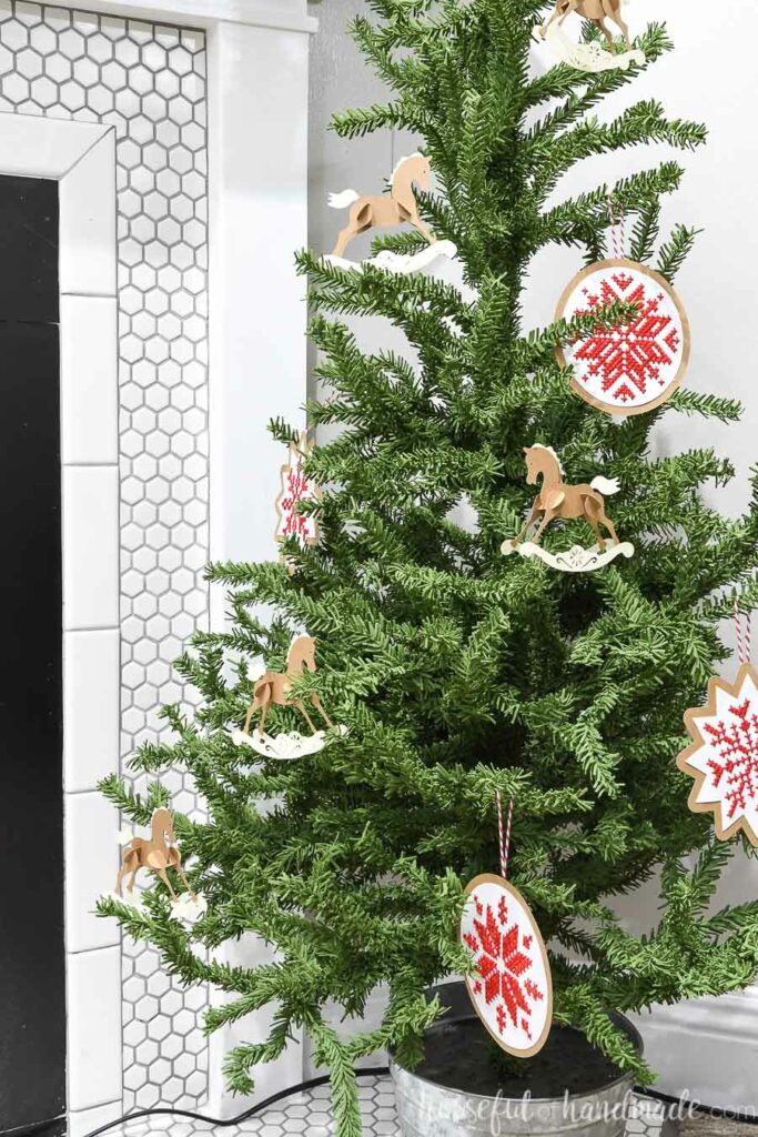 Christmas tree with paper ornaments hanging including paper rocking horses and nordic ornaments