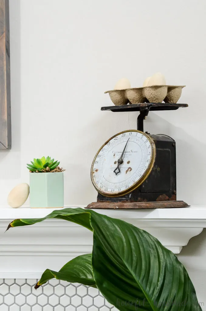 vintage scale with egg holder on top of spring mantel