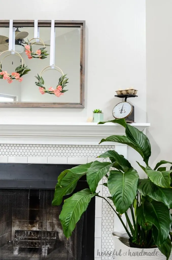 3 hoop wreaths on mirror above spring mantel with plant
