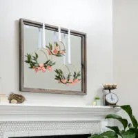 Gray mirror over fireplace with simple spring mantel decor on and around it.