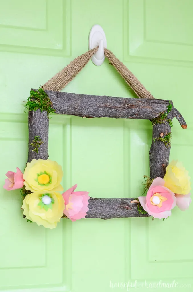 spring wreath with tree branches on green door