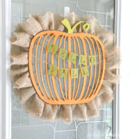 Close up of the wood pumpkin shaped wreath with burlap around the outside and the Give Thanks banner hanging on it.