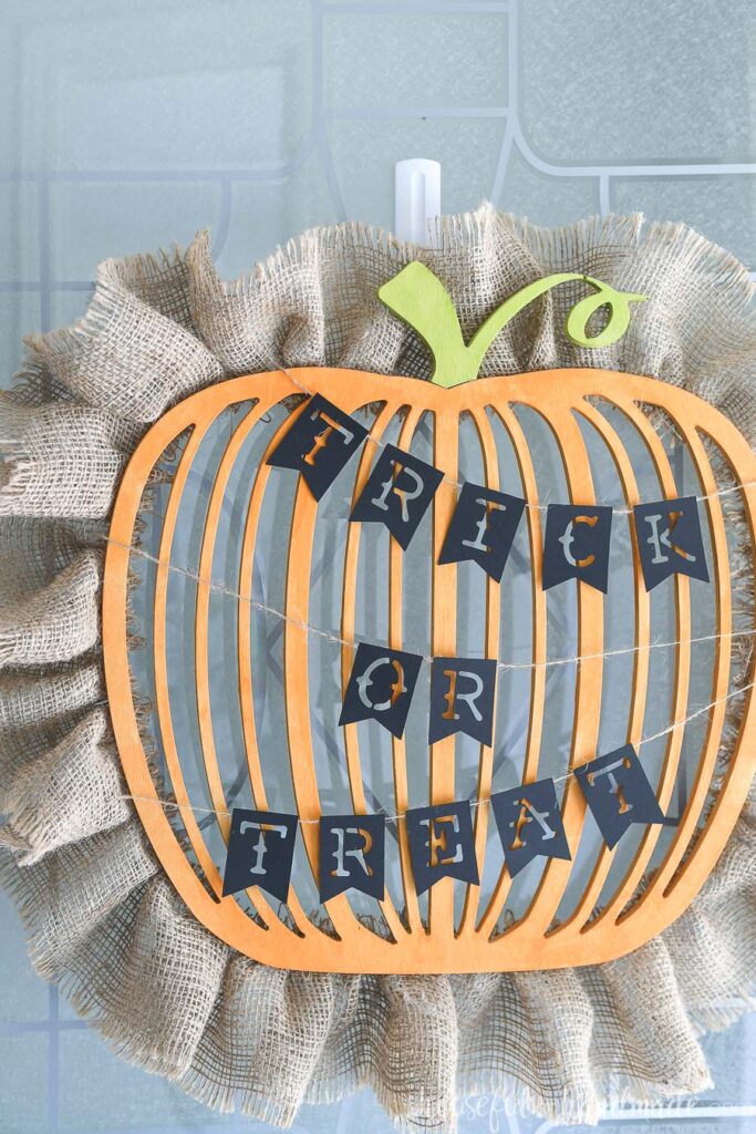 Close up of the Trick or Treat banner attached to the wood pumpkin wreath. 