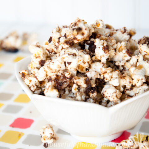 Tulip bowl on a colorful placemat filled with german chocolate cake caramel popcorn.