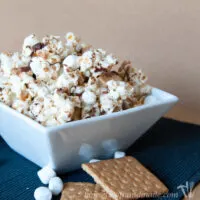 Square white bowl with s'mores caramel popcorn inside it.