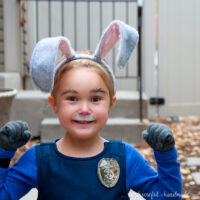 Young girl wearing a DIY Judy Hopps halloween costume with ears and face painted as a bunny.