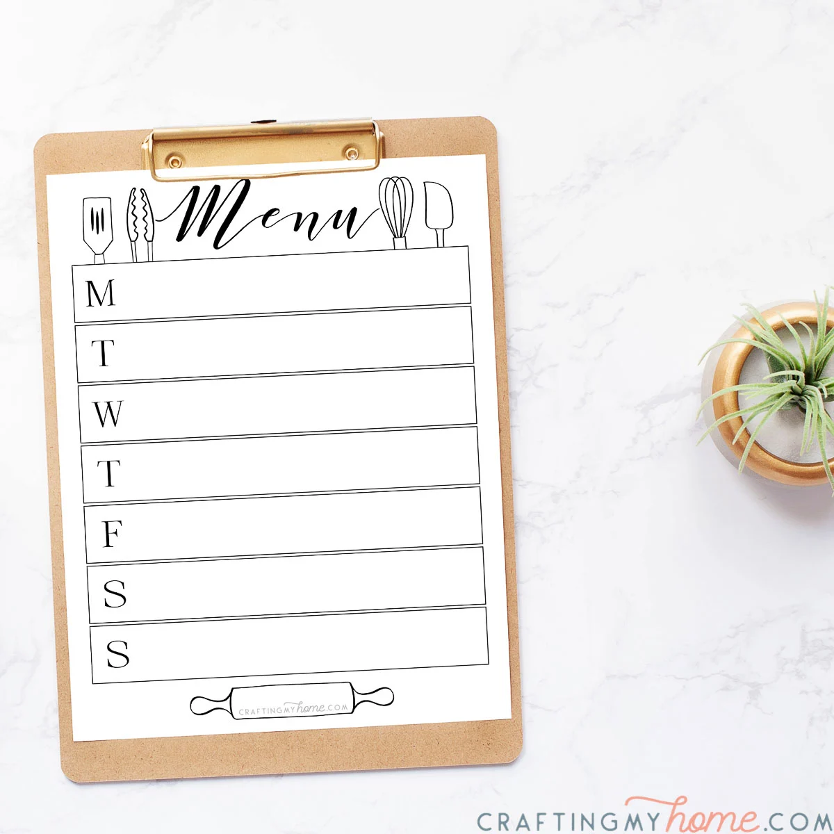 White and black printable menu board on a clipboard next to a small plant. 