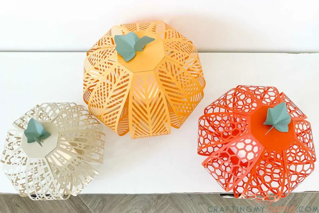 Top down view of the beautiful paper pumpkin lanterns on a white console table. 