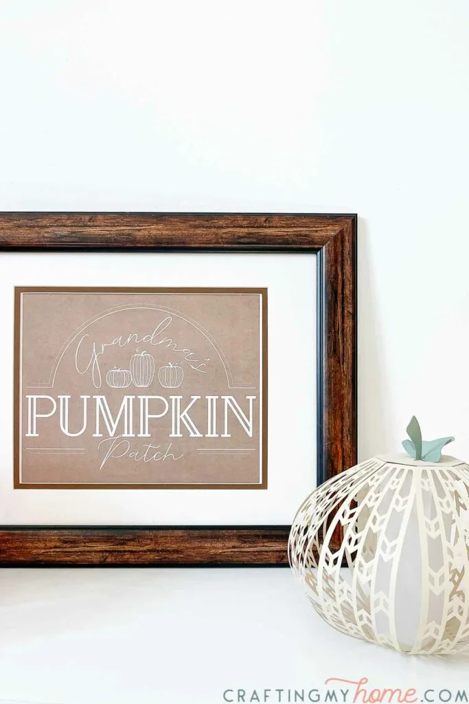 Close up of the Grandma's Pumpkin Patch sign in a frame with a paper pumpkin next to it. 