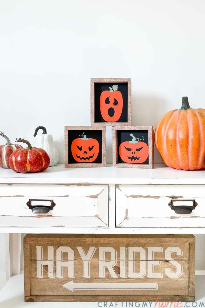 Halloween vignette created on a white side table with the simple Halloween signs, pumpkins, and Hayrides sign. 